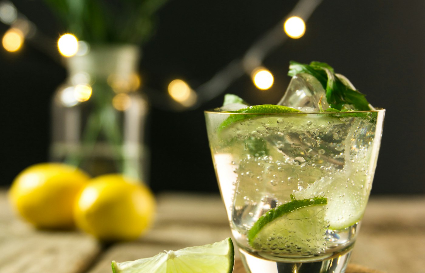 Fresh lime and mint cocktail served at an evening event with string lights